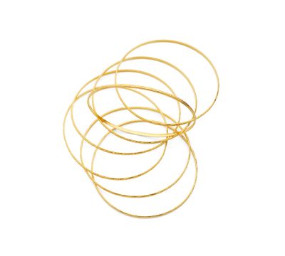 un gros plan sur une pile de bracelets en or sur fond blanc