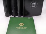 three black and green books sitting next to each other on a table