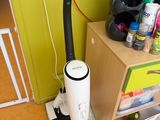 a vacuum that is sitting on the floor next to a cabinet
