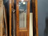 a wooden cabinet with a glass door in the middle of it