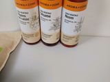 three bottles of liquid sitting on top of a table next to a bag