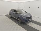 Une voiture bleue est garée dans une pièce blanche au sol à carreaux.