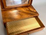 a small wooden table with a mirror on top of it