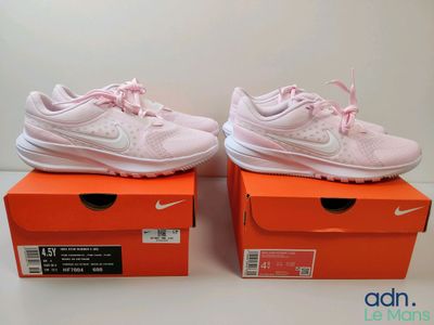a pair of pink shoes are sitting on top of a box