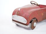 a red toy car that is sitting on a white surface