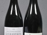 two bottles of wine sitting next to each other on a table