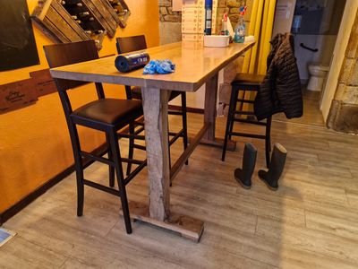 une table en bois avec deux chaises et un tableau noir accroché au mur