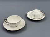 deux tasses et soucoupes blanches posées sur une table