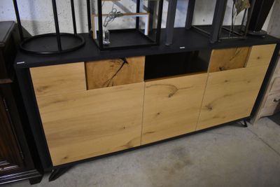 une commode noire et en bois surmontée de deux lampes noires