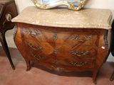 a marble top chest of drawers with a mirror on top of it
