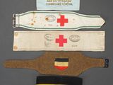 three pieces of cloth with a red cross and a german flag on them