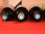 several bottles of wine are lined up on a red surface