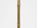 tall gold bamboo floor lamp with a white background
