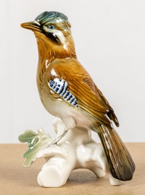 a figurine of a bird sitting on a branch