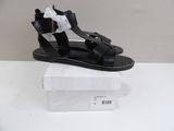 black leather sandals with bows on the toes are on a white box
