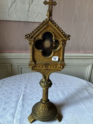 une horloge en or surmontée d'une croix