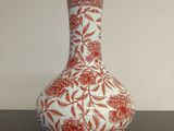 un vase rouge et blanc posé sur une table noire