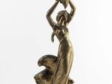 a bronze statue of a woman holding a pot on her head