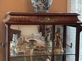 a display case with a vase on top of it in a living room