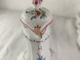 a white vase with a flower design on it on a table