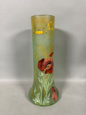 un vase vert orné de fleurs rouges, posé sur une table
