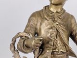 bronze statue of a boy holding a fish in his hand