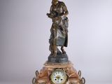 une statue de femme tenant une horloge sur une table
