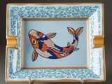 a blue and orange plate with a fish on it