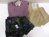 three pairs of men ' s shorts and a t - shirt on a white table