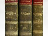 trois vieux livres posés l'un sur l'autre sur une surface blanche