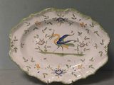 a plate with a bird on it on a stand