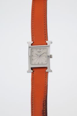 a close up of a wrist watch with an orange strap