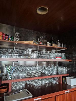 un bar avec beaucoup de verres sur les étagères