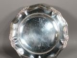 une assiette en argent antique avec un motif décoratif sur le bord