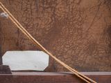 a piece of paper taped to a piece of wood with a rope