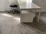 a desk with a chair and a window in the room
