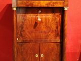une armoire en bois munie d'une porte, dans une pièce