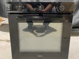 Quelqu'un prend une photo d'une cuisinière dont le reflet apparaît sur la porte du four.
