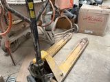 un chariot élévateur qui se trouve au sol, à côté d'une pile de cartons