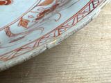 a white plate with red designs on it on a table