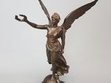 statue en bronze d'une femme tenant un oiseau sur un socle en marbre