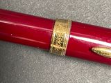 a red pen with a gold trim on it