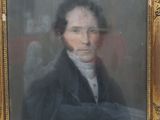 portrait of a man in a black coat and white shirt sitting in front of a red chair