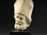 a white marble head of a man wearing a hat