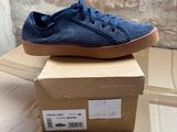 blue sneakers on a cardboard box with a brick wall in the background