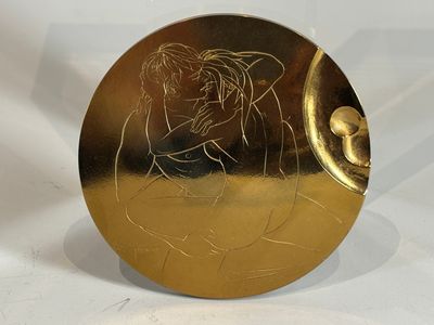 a gold plate with a picture of a woman on it