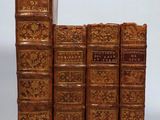three books are stacked on top of each other on a white surface