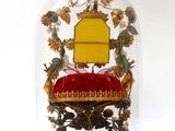 a glass dome with a red cushion inside of it