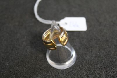 une bague en or posée sur un présentoir transparent, sur un fond noir
