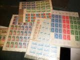 beaucoup de timbres posés sur une table, à côté d'une feuille de papier
